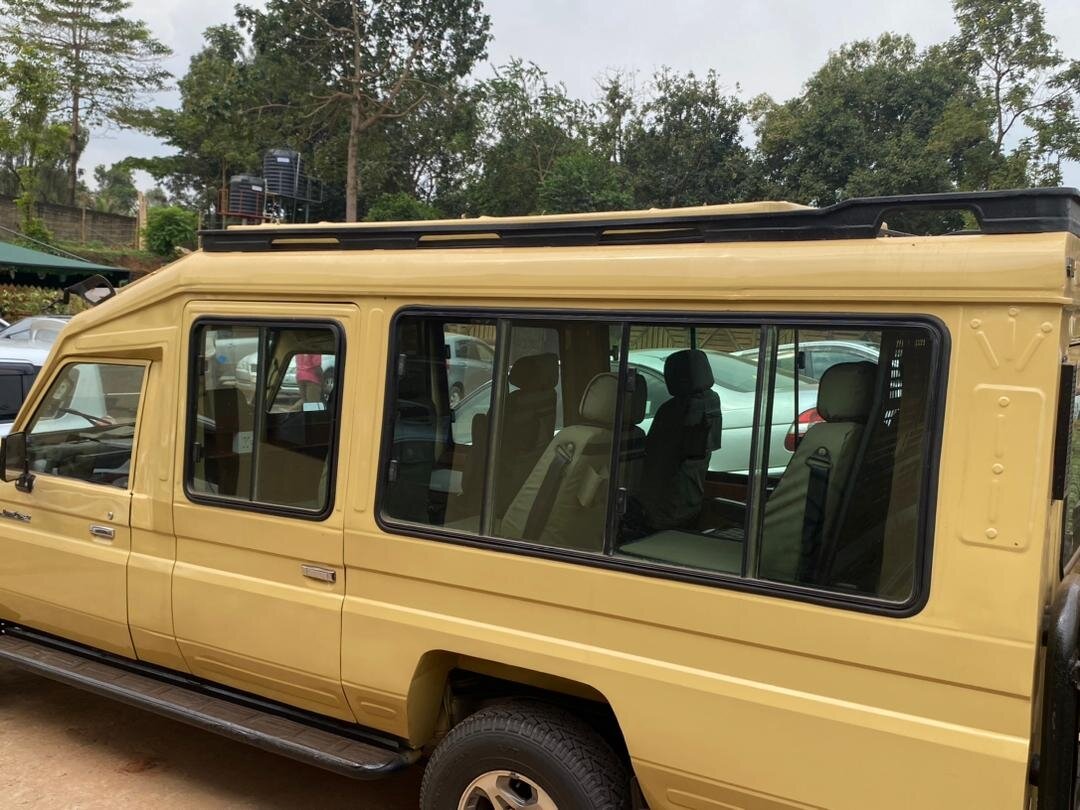 A yellow pop-top safari Land Cruiser parked on a track in Ruaha